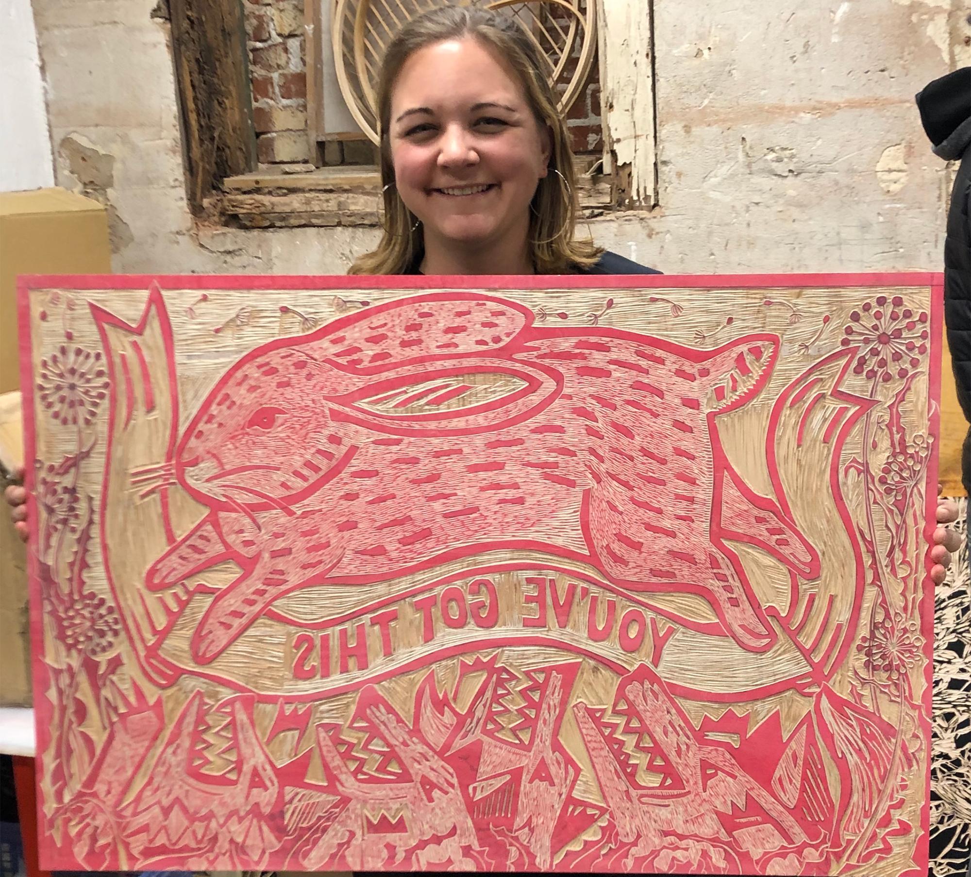 Artist Jillian Roper with a woodblock print of a rabbit