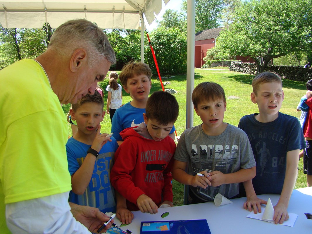 A volunteer shows a group of young park visitors an activity.