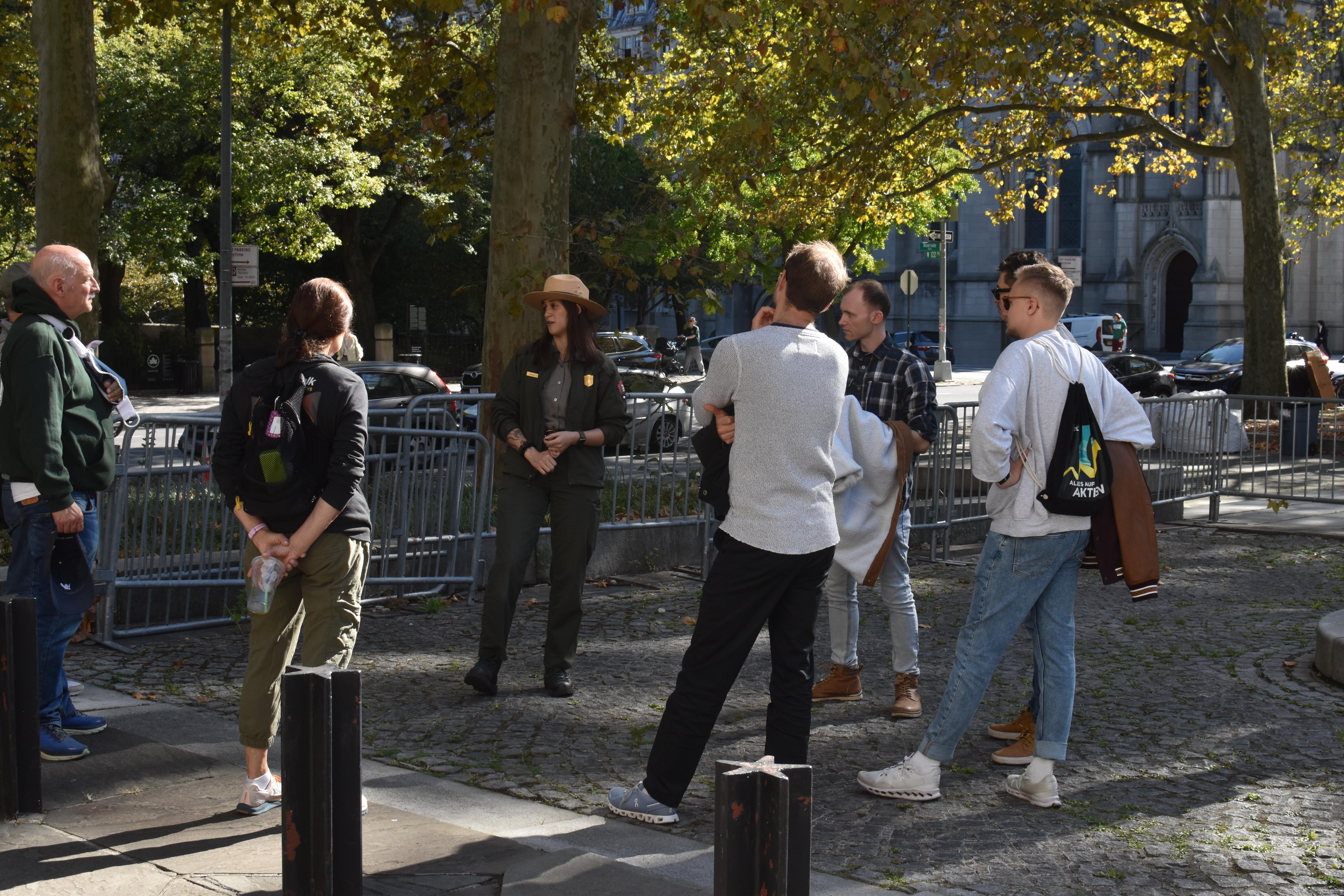 A uniformed park ranger stands with a group of visitors.