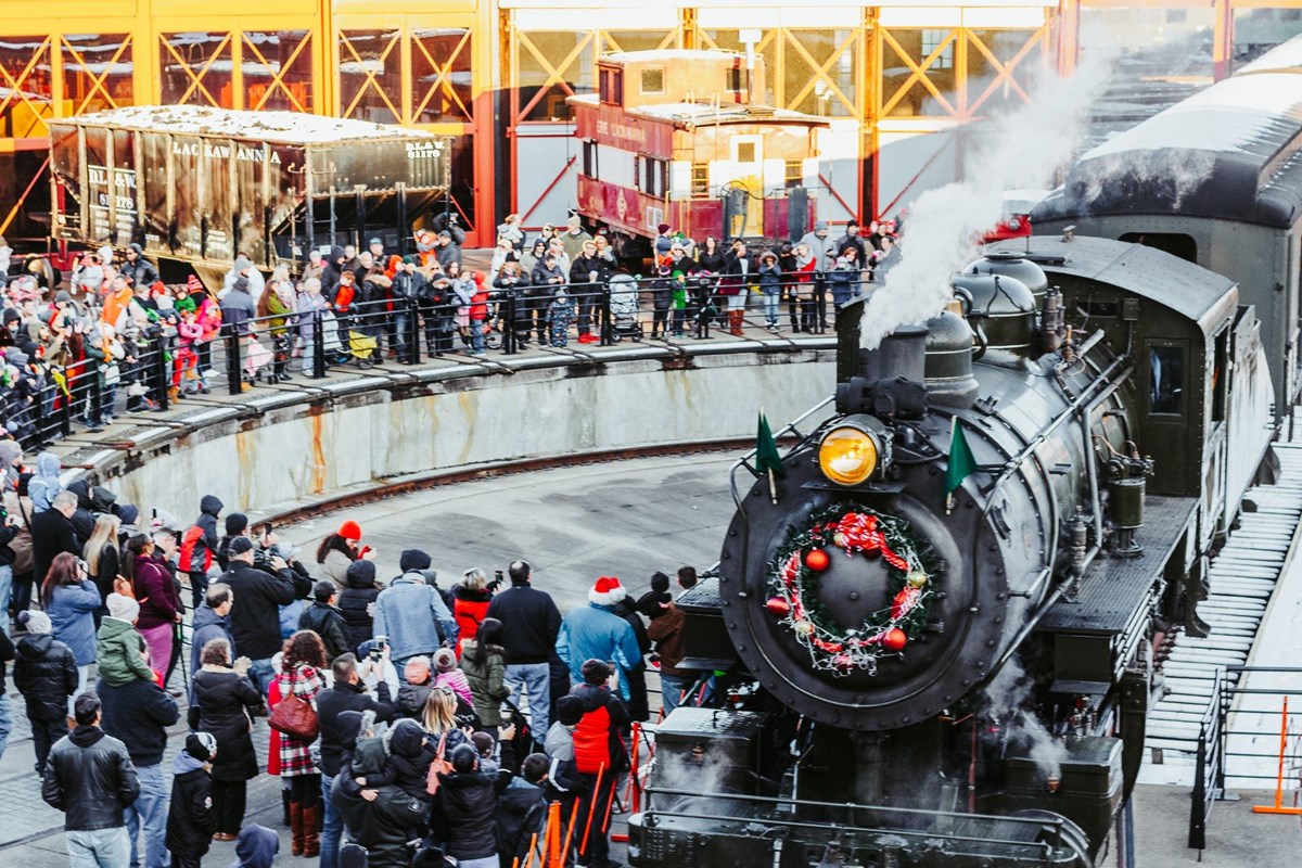 Steam engine on a turn table as a large crowd gathers to see Santa