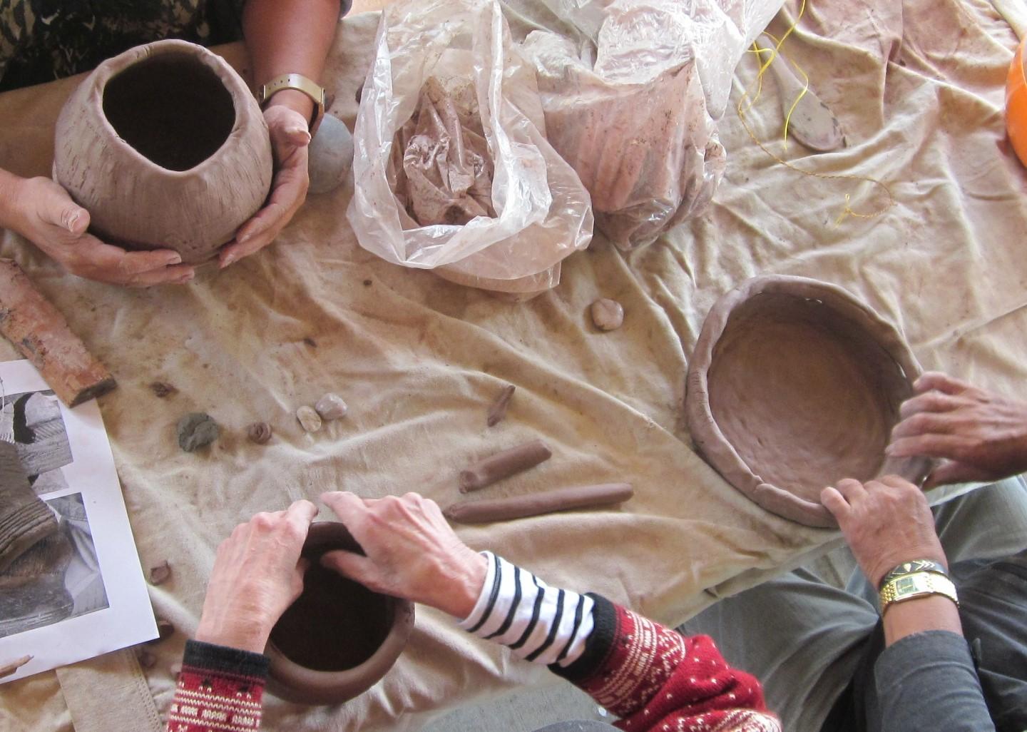 Peoples hands forming pots