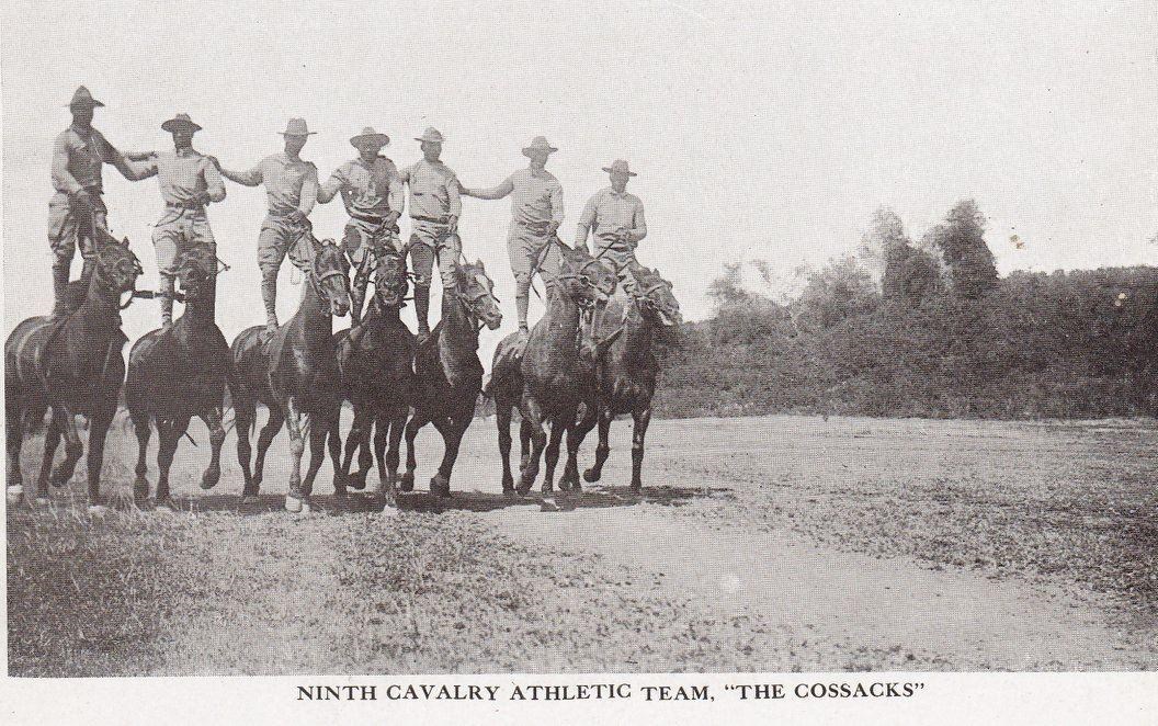 Seven Black soldiers skillfully riding horses during a training exercise.