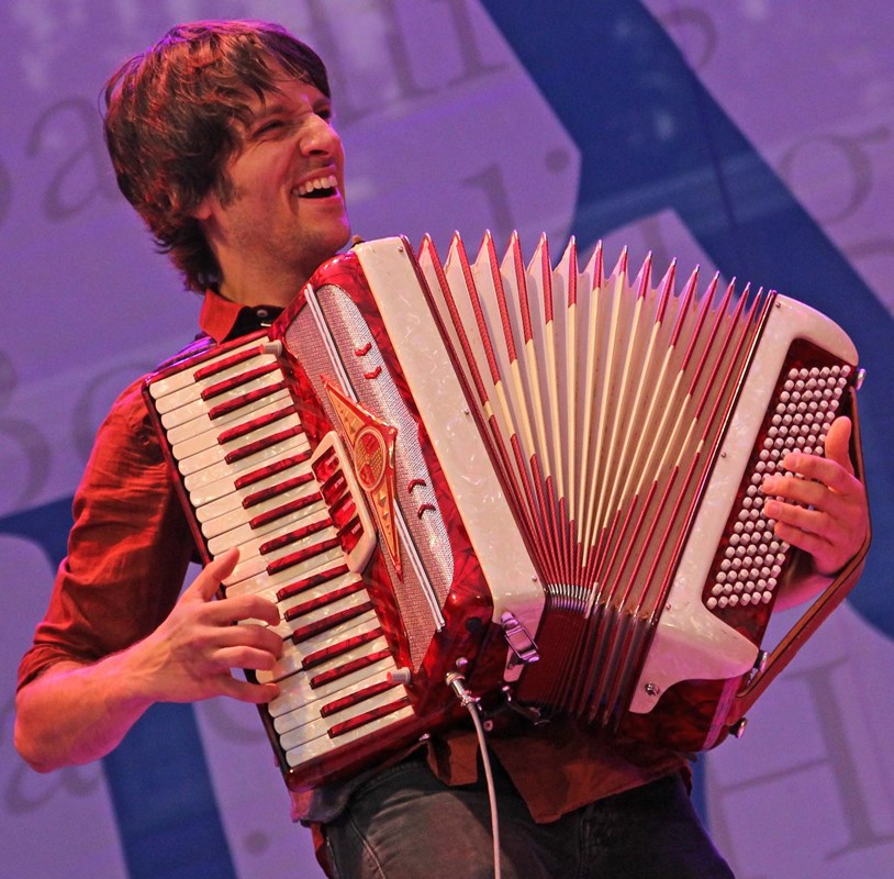 A musician plays the accordion during a concert