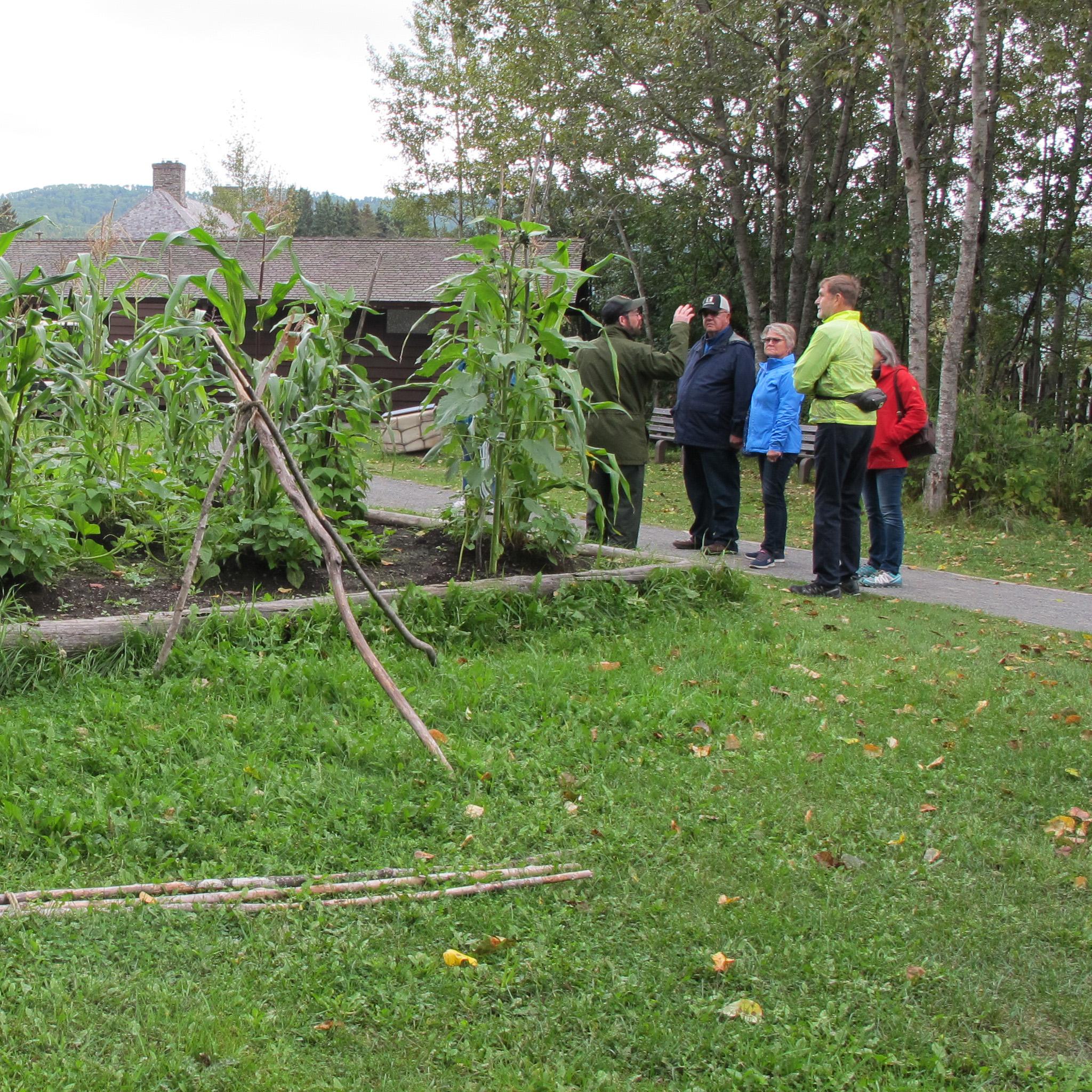 An interpretive ranger talks to visitors near the Three Sisters Garden.