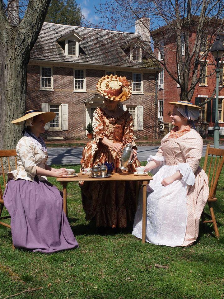 Three women sit on The Dover Green drinking tea
