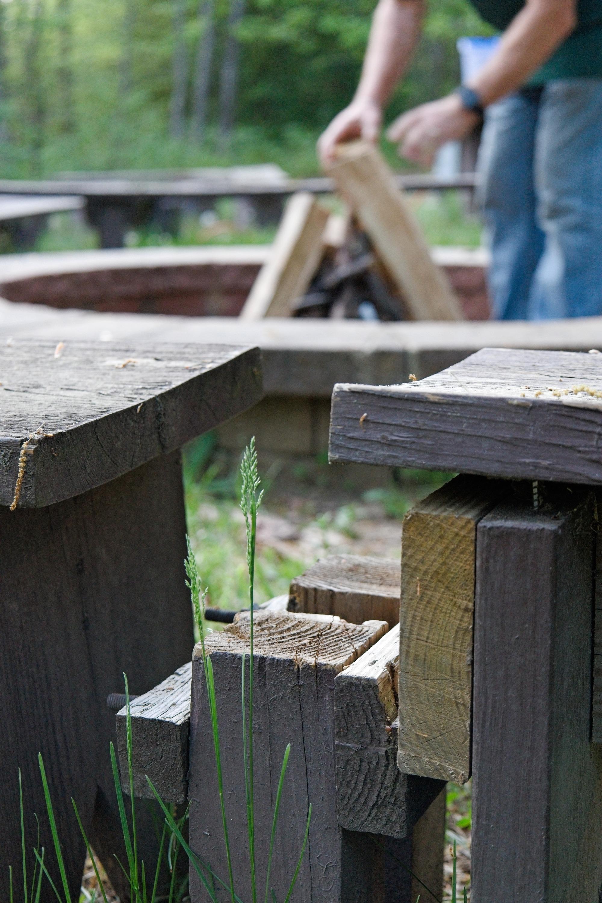 A NPS volunteer prepares the wood and firepit for a campfire event at Greenbelt Park on April18,2026