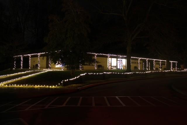 A color photo showing the Birthplace Visitor Center at night decorated in white Christmas lights