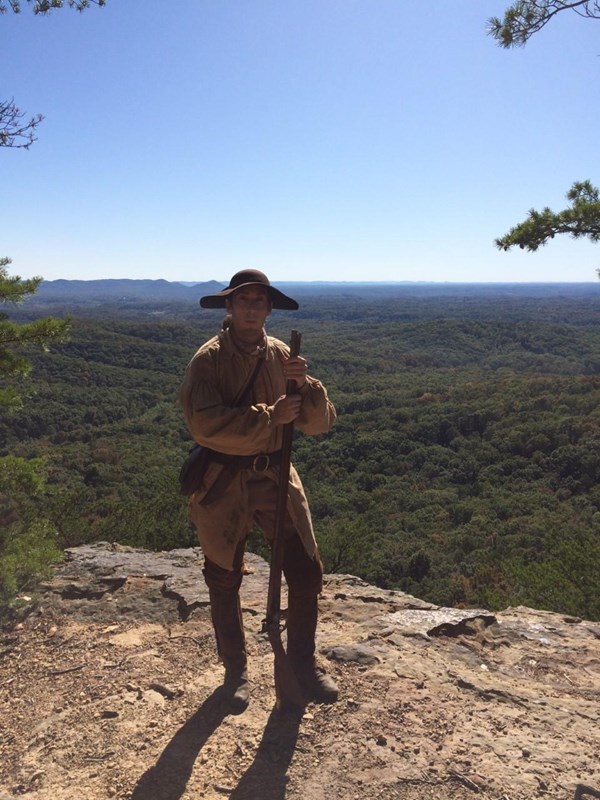 a man standing at an overlook dressed in Long Hunter attire