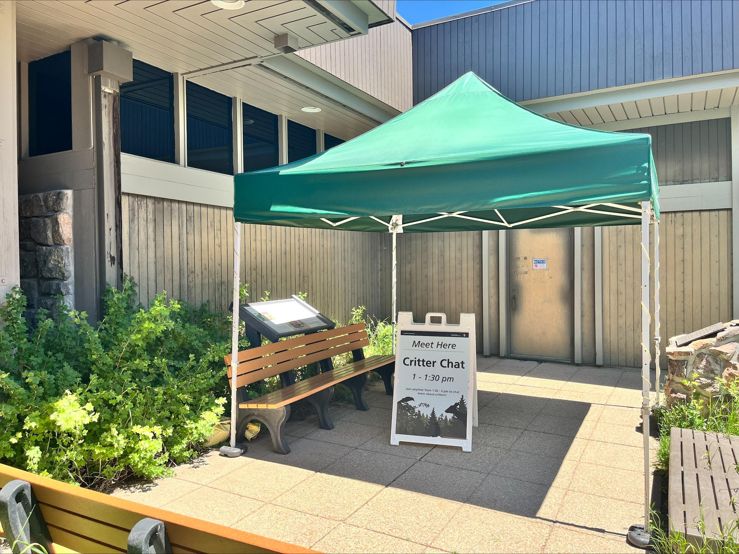 Tent on the outdoor patio with a sign for the Critter Chat - Meet Here