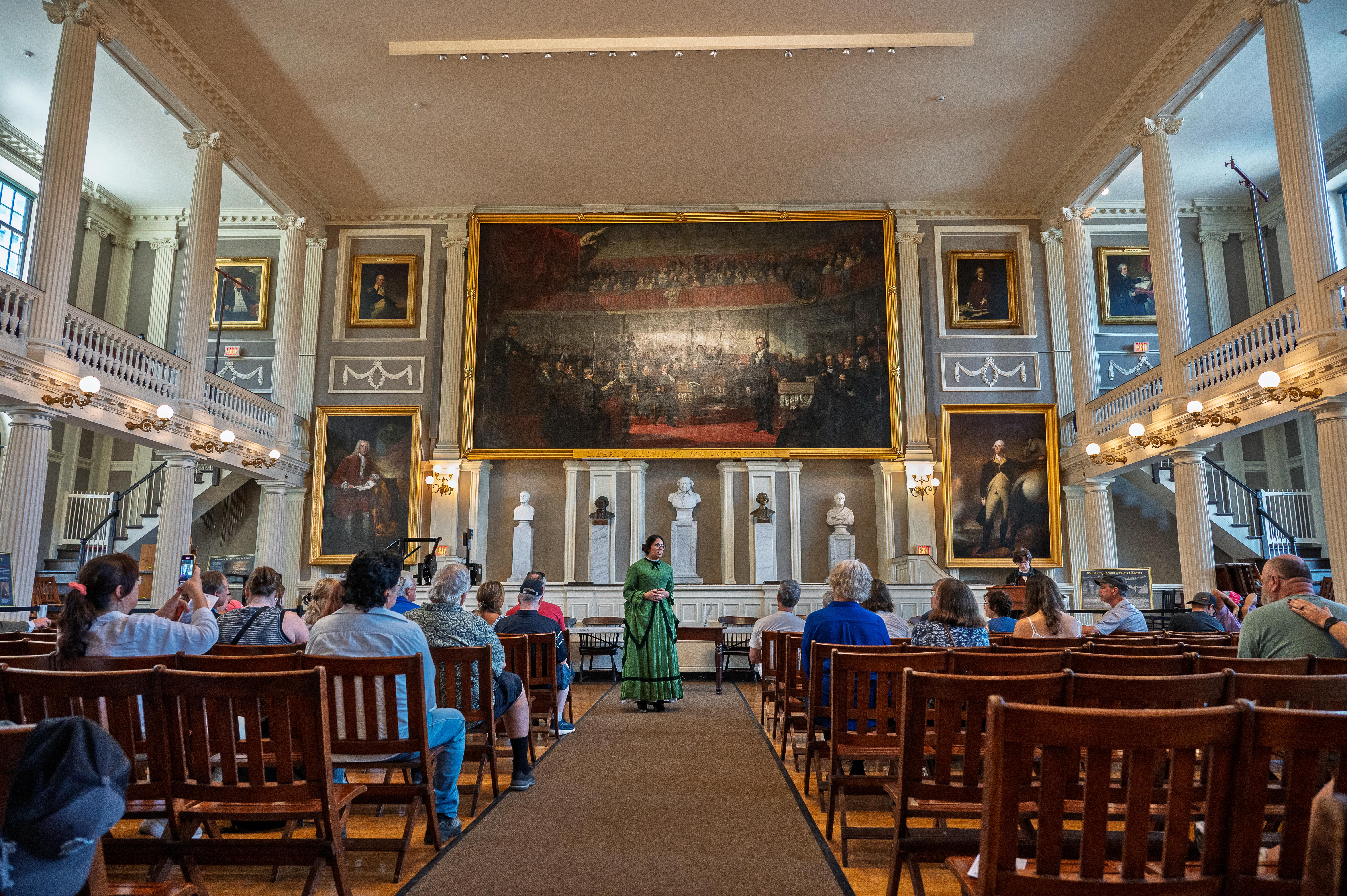 Photo of Rangers dressed in historic clothing in a large room with lots of people watching