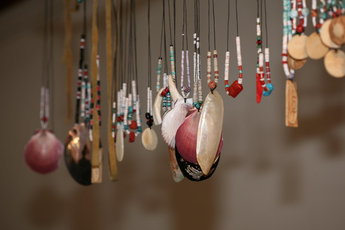 Close up of beaded necklaces hanging in a row.