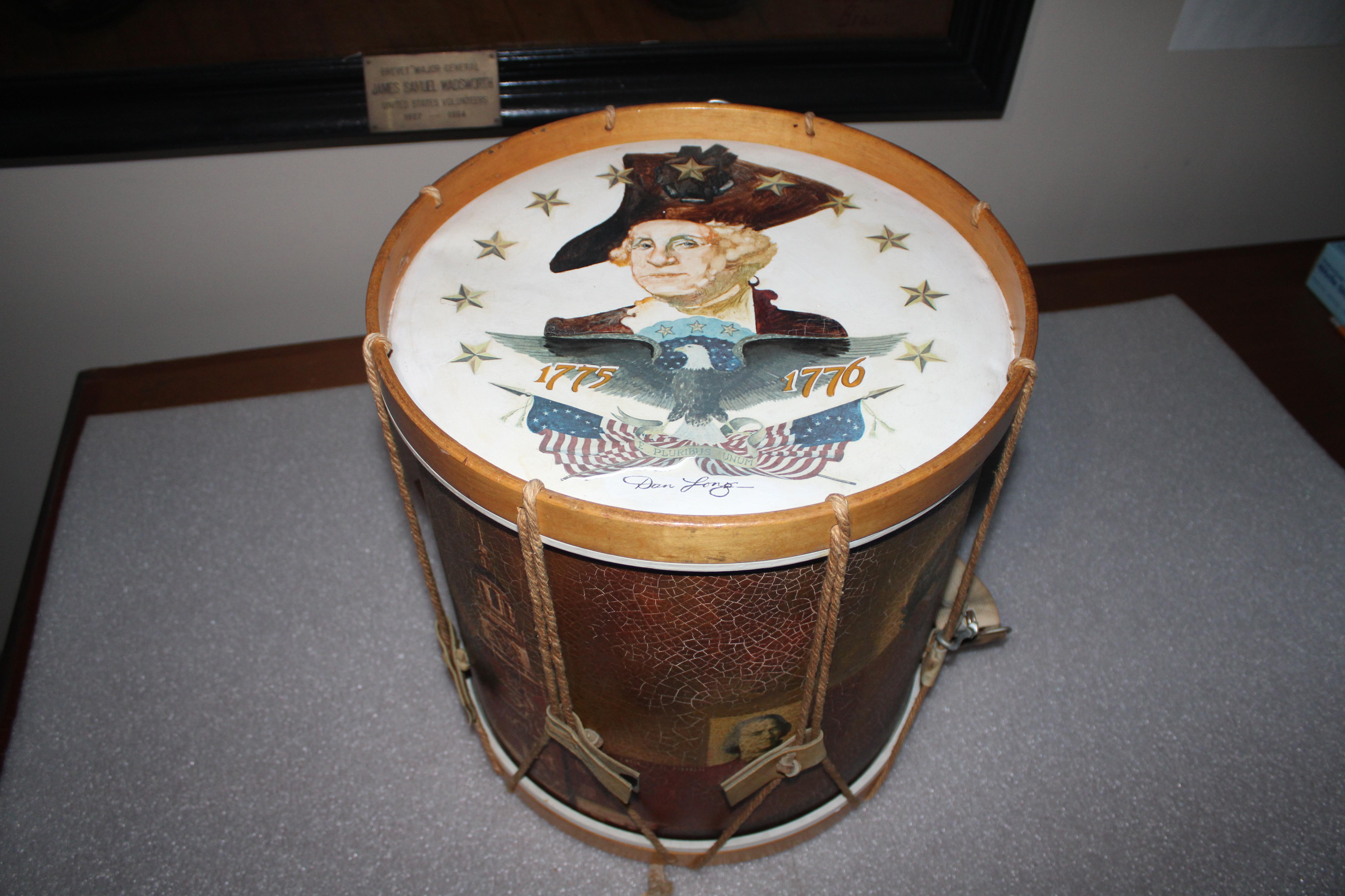 Drum featuring face and torso of man in white wig with black hat
