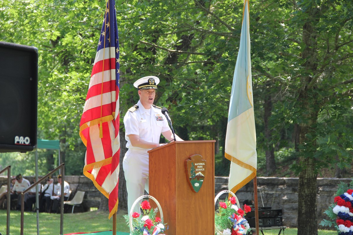 A US Navy officer in dress whites speaks during a Memorial Day event.