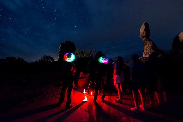 Ranger and visitors stargazing at Balanced Rock.
