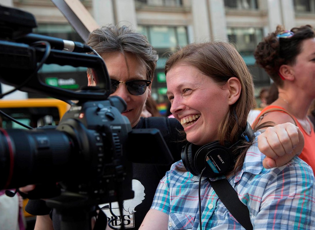 Megan is on location behind the camera laughing with a pal