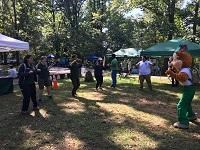 Two men and three women are dancing with Woodsy the Owl, mascot of the U.S. Forest Service.