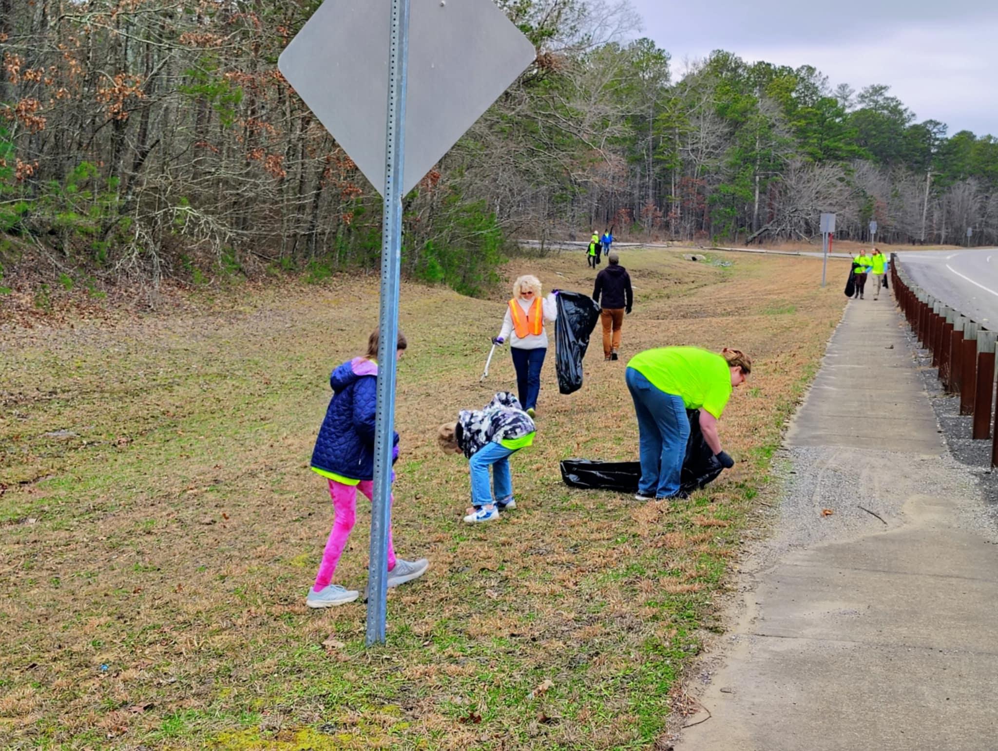 people pick up trash near road