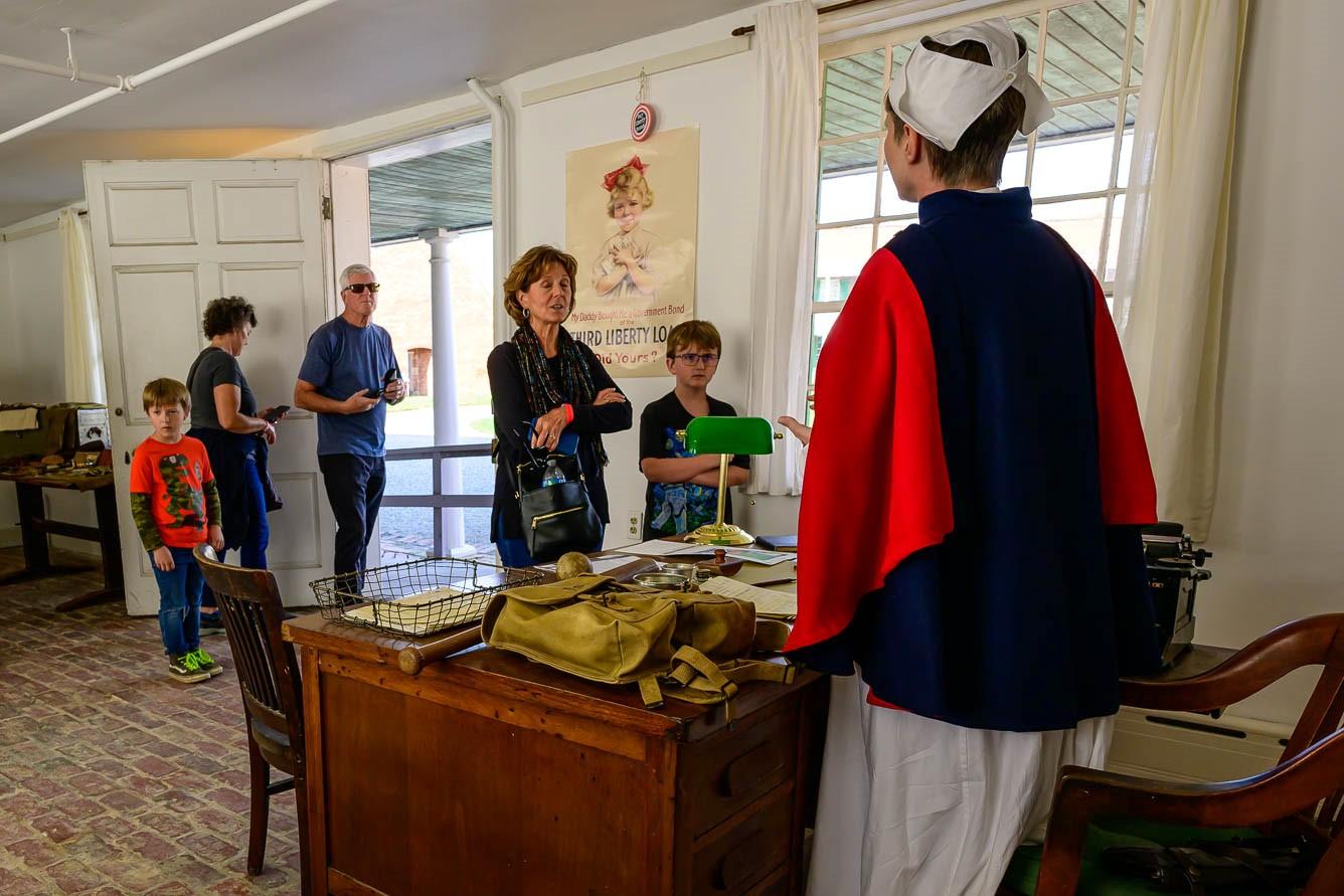 Visitors, including children and adults, speak with a living historian dressed as a WWI era nurse.
