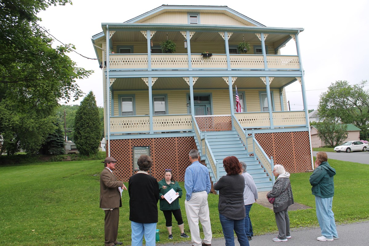A costume park ranger leads a walking tour of cottage row.
