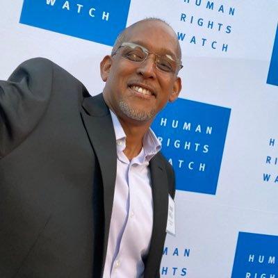 Joseph Bell Jr a black man with glasses a light goatee takes a self portrait photo.