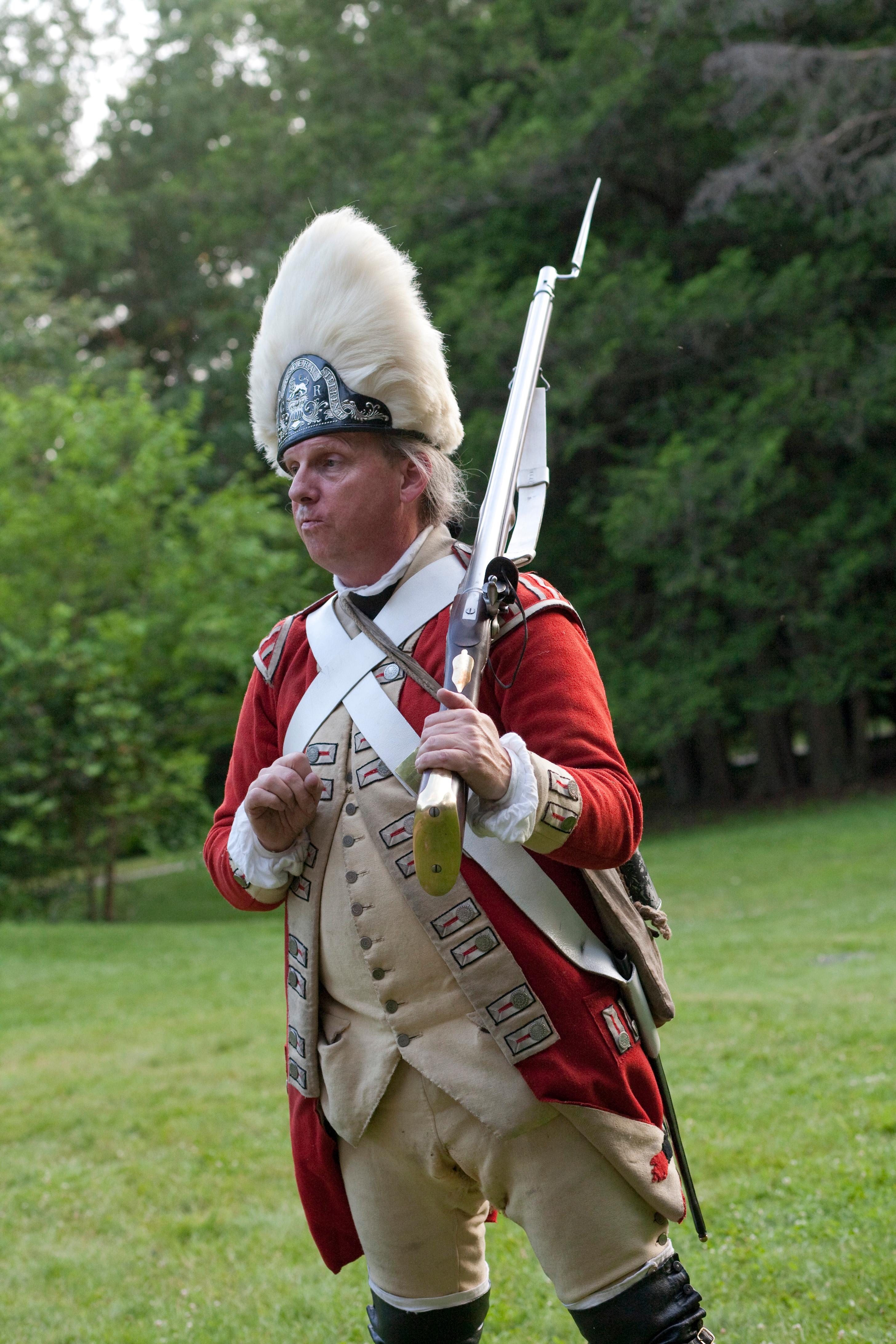 A British Soldier in red coat and military uniform with a musket