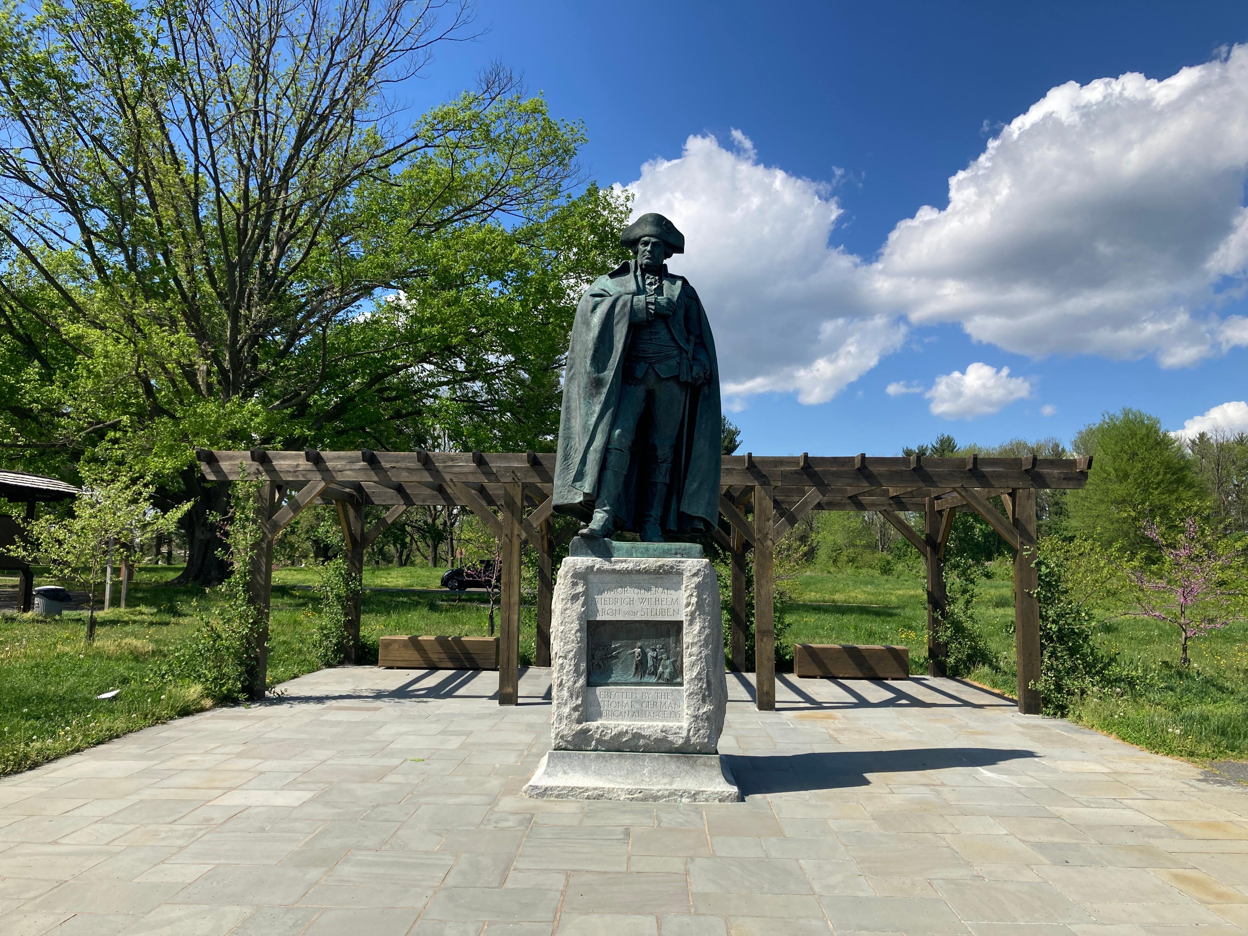 photograph, outdoors, statue, pavement, trees, sky, cloud