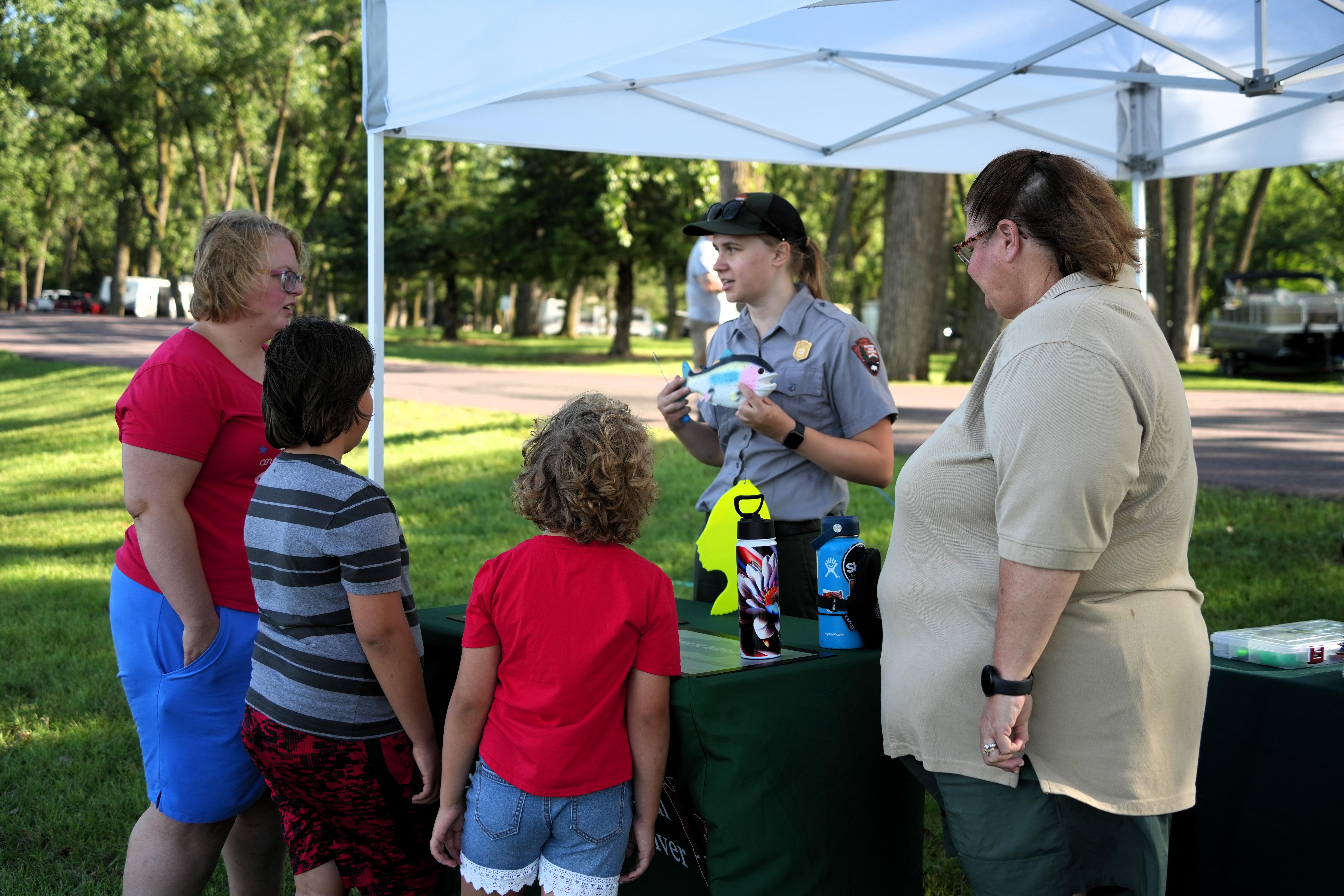 Park rangers guide fishing clinic participants in educational fishing stations