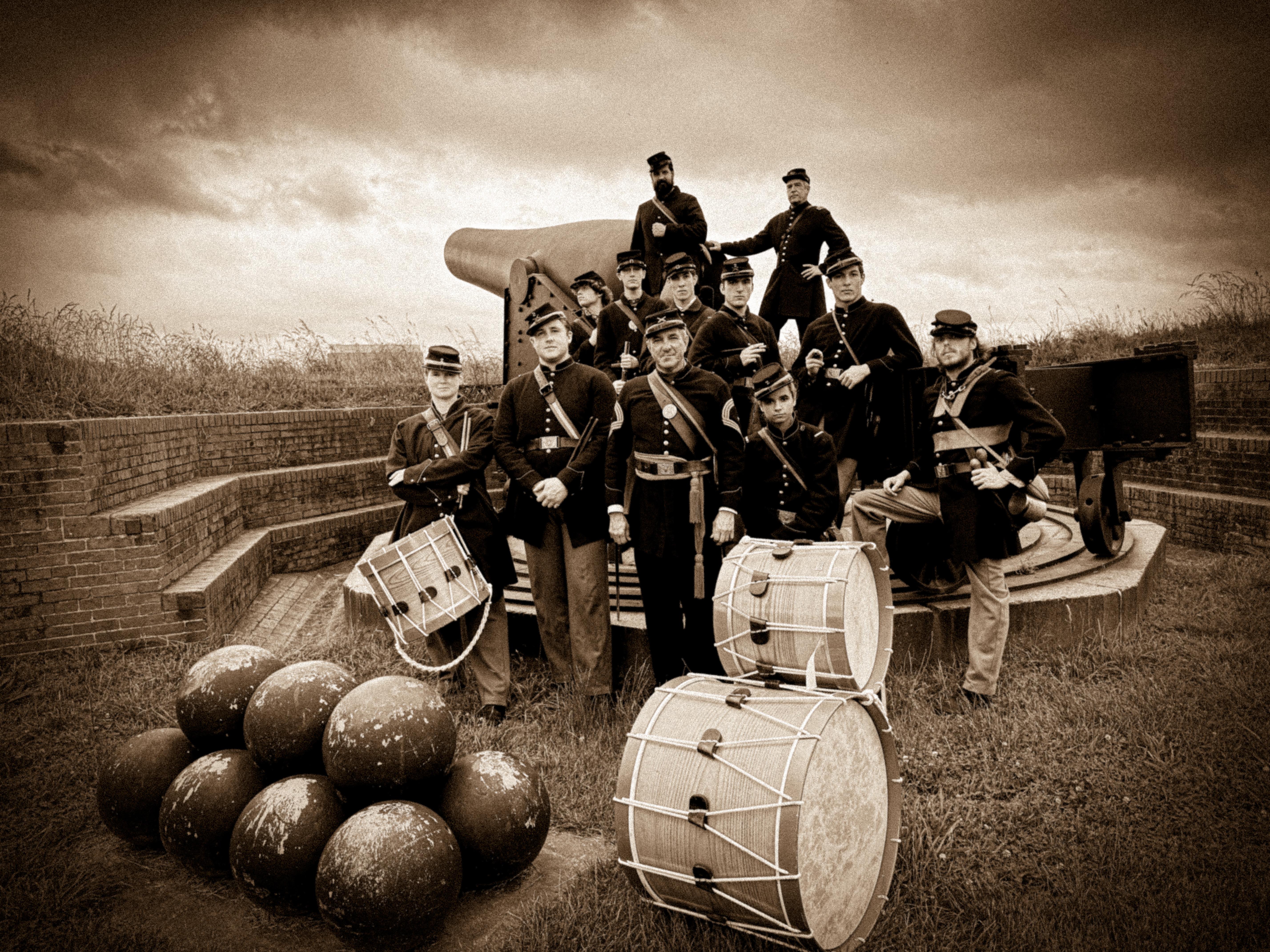 Living history volunteers in Civil War unforms posing with Rodman gun