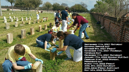 A number of people clean headstones in a cemetery.