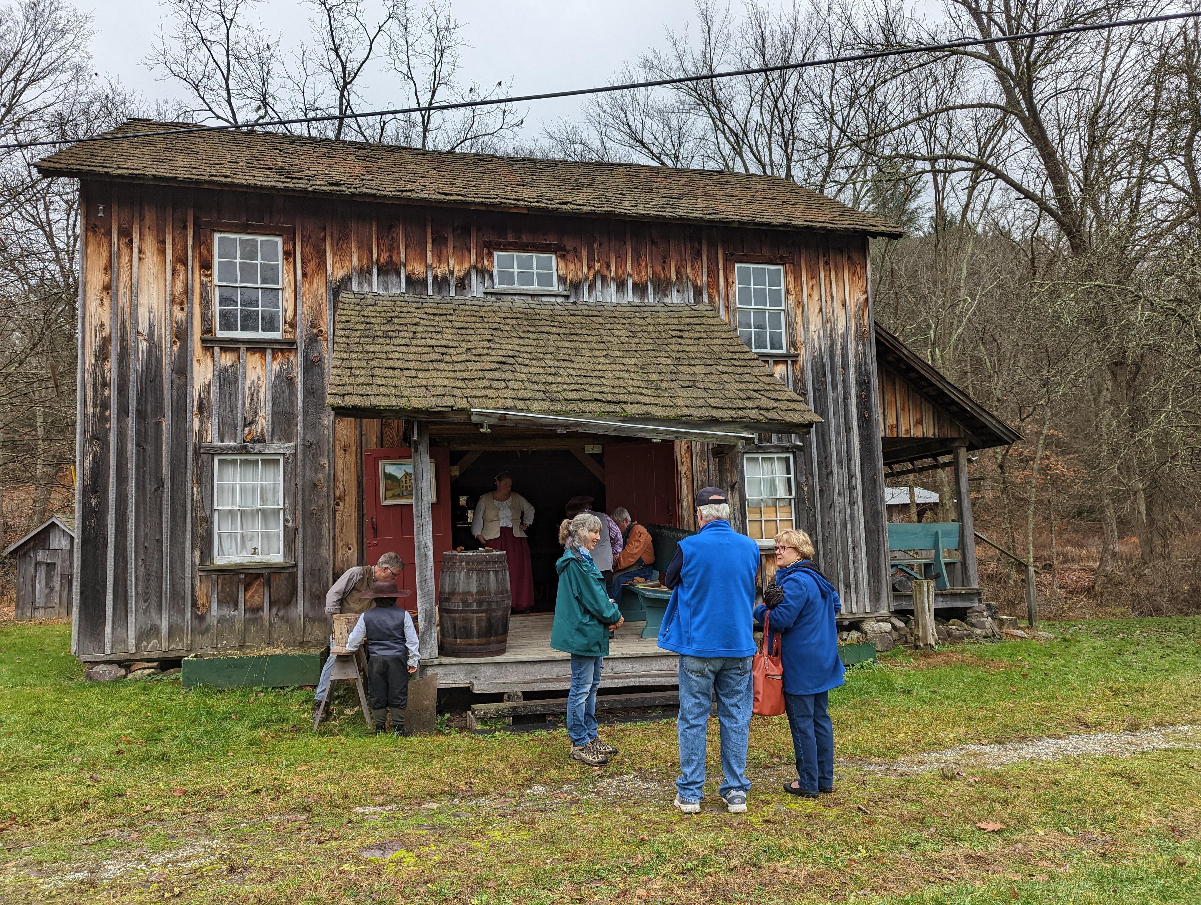 Visitors standing in front of an old wooden house.