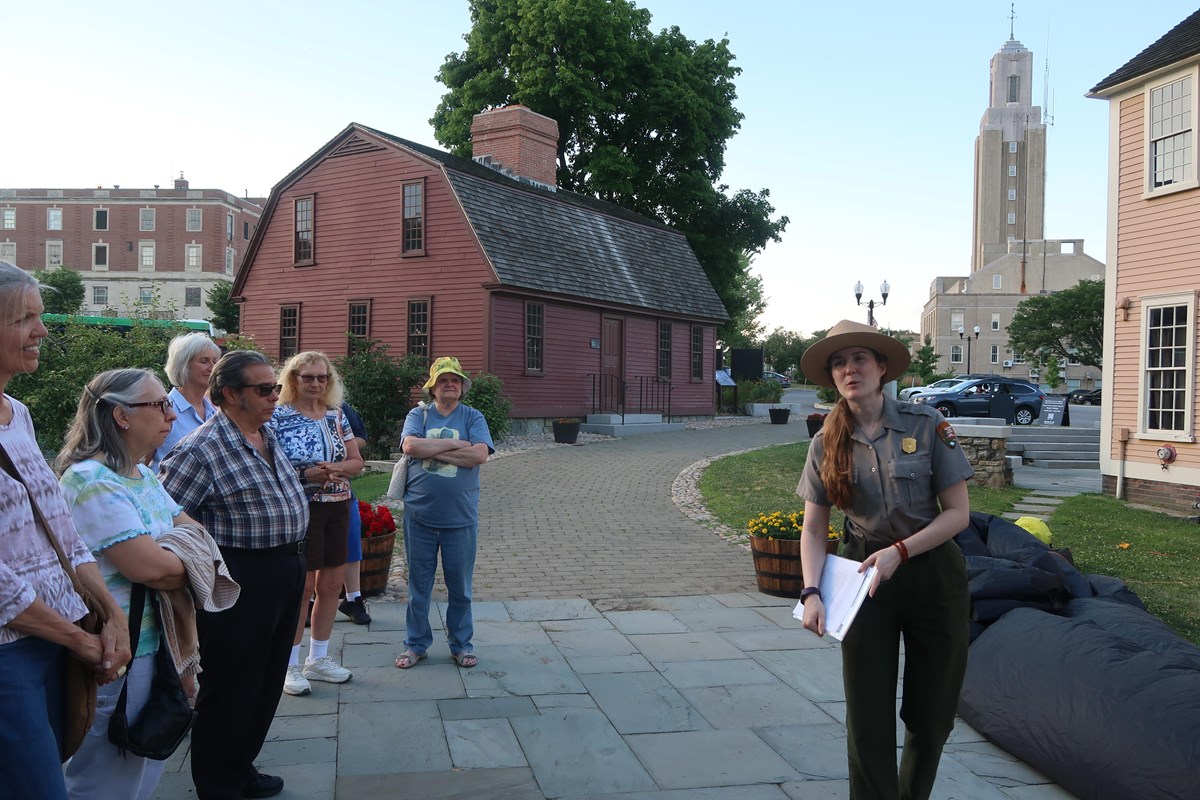 Ranger talking to a group of people in front of a red building