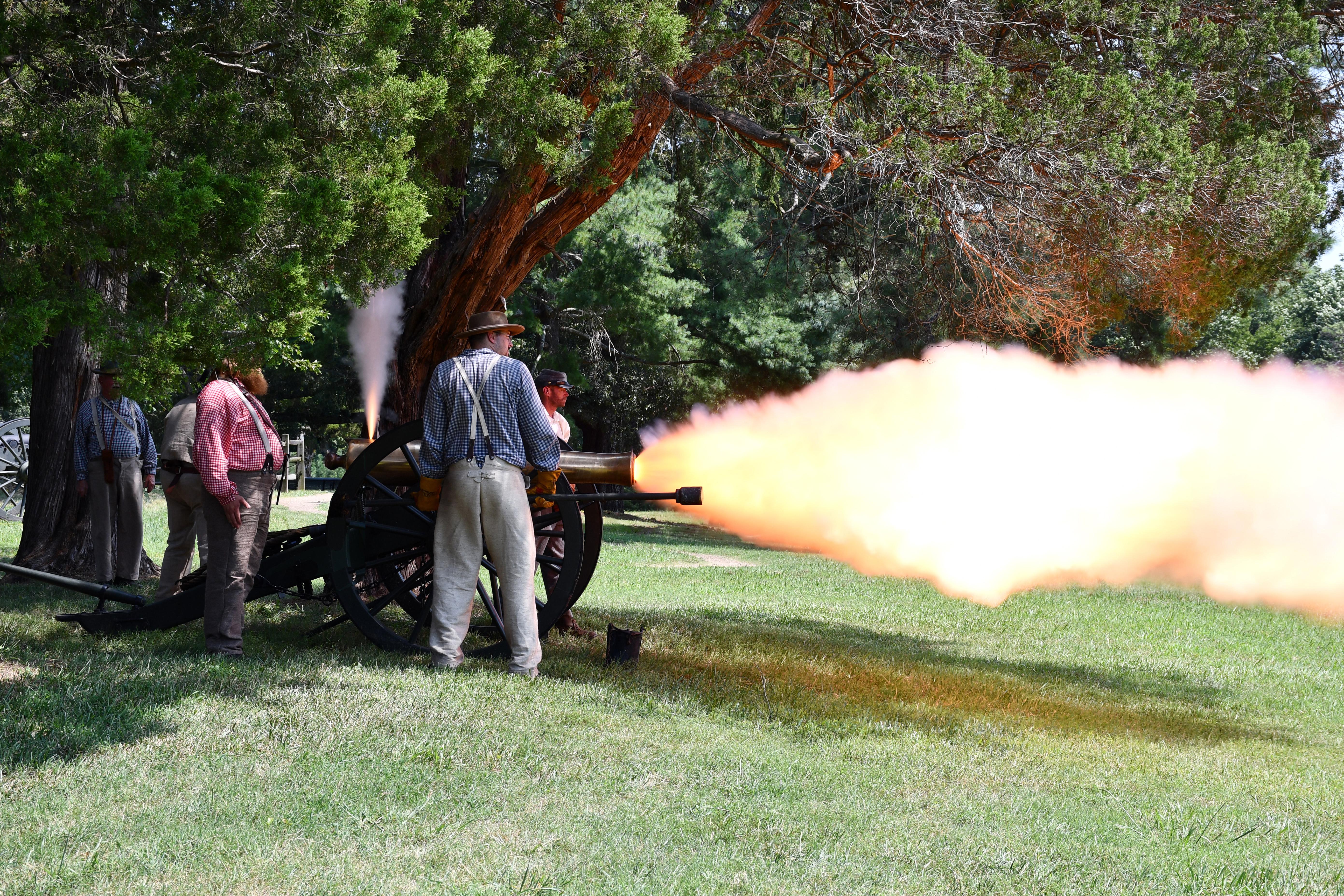 Living historians fire a cannon.