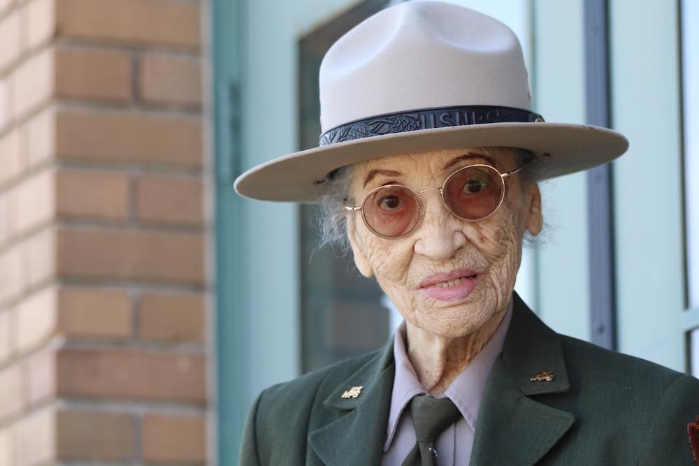 Senior African American Woman in a ranger uniform smiles at camera.