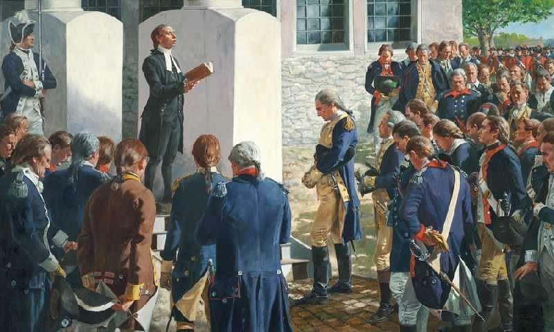 Chaplain in period clothing speaking to a group of colonial soldiers