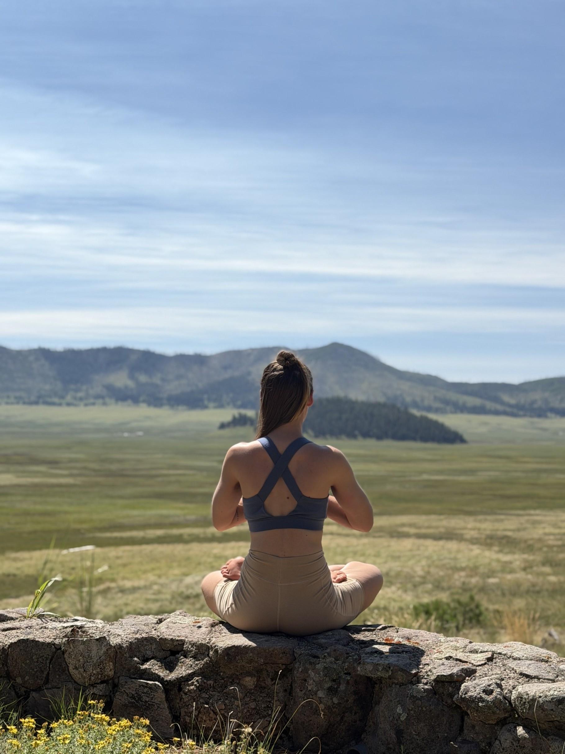 A woman doing yoga in a montane grassland