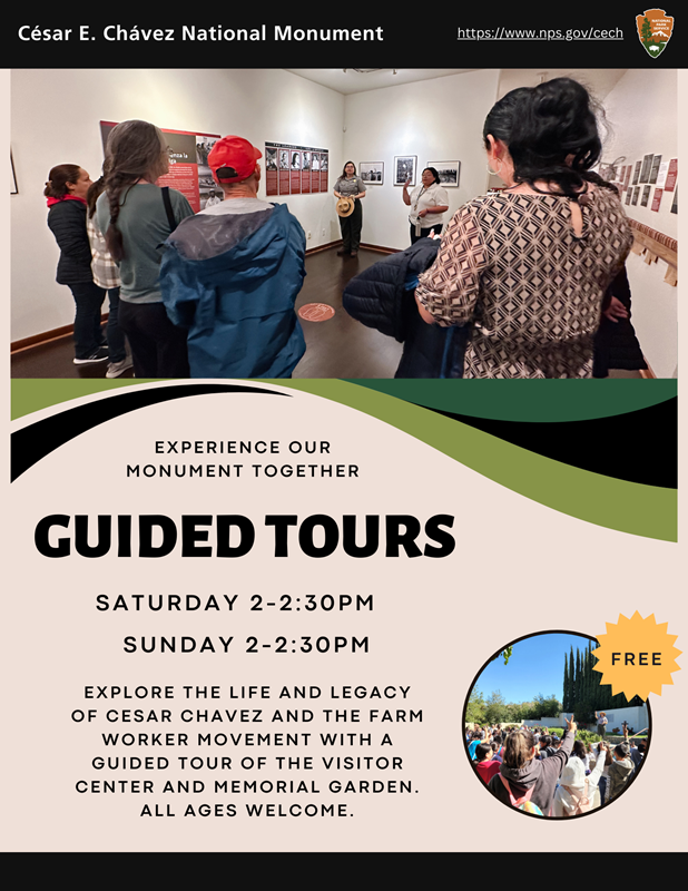 A group of visitors stands around a park ranger in a museum. Text that says