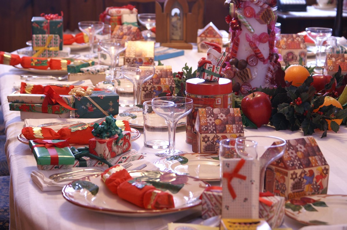 A table set for Christmas dinner with many decorations.