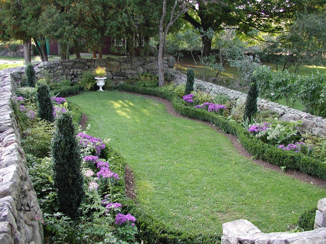 A sunken garden with a stone wall surrounding it.
