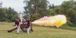 An 18th century cannon fires with aplume of flame and smoke coming out of the cannon