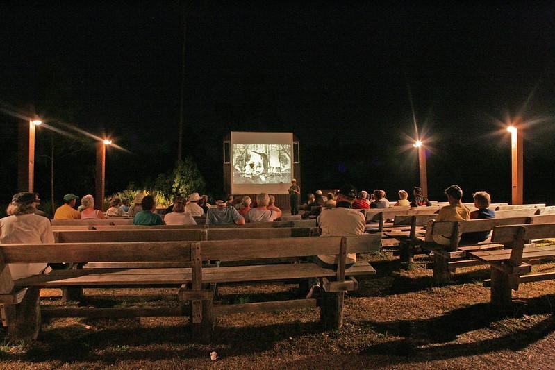 The Long Pine Key Amphitheater, a ranger stands in front of an audience with a screen in the back.