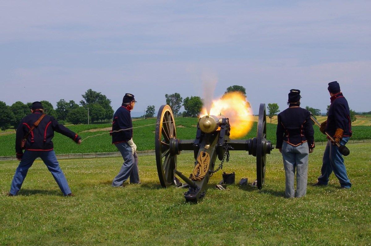 Four volunteers dressed as soldiers fire a cannon.