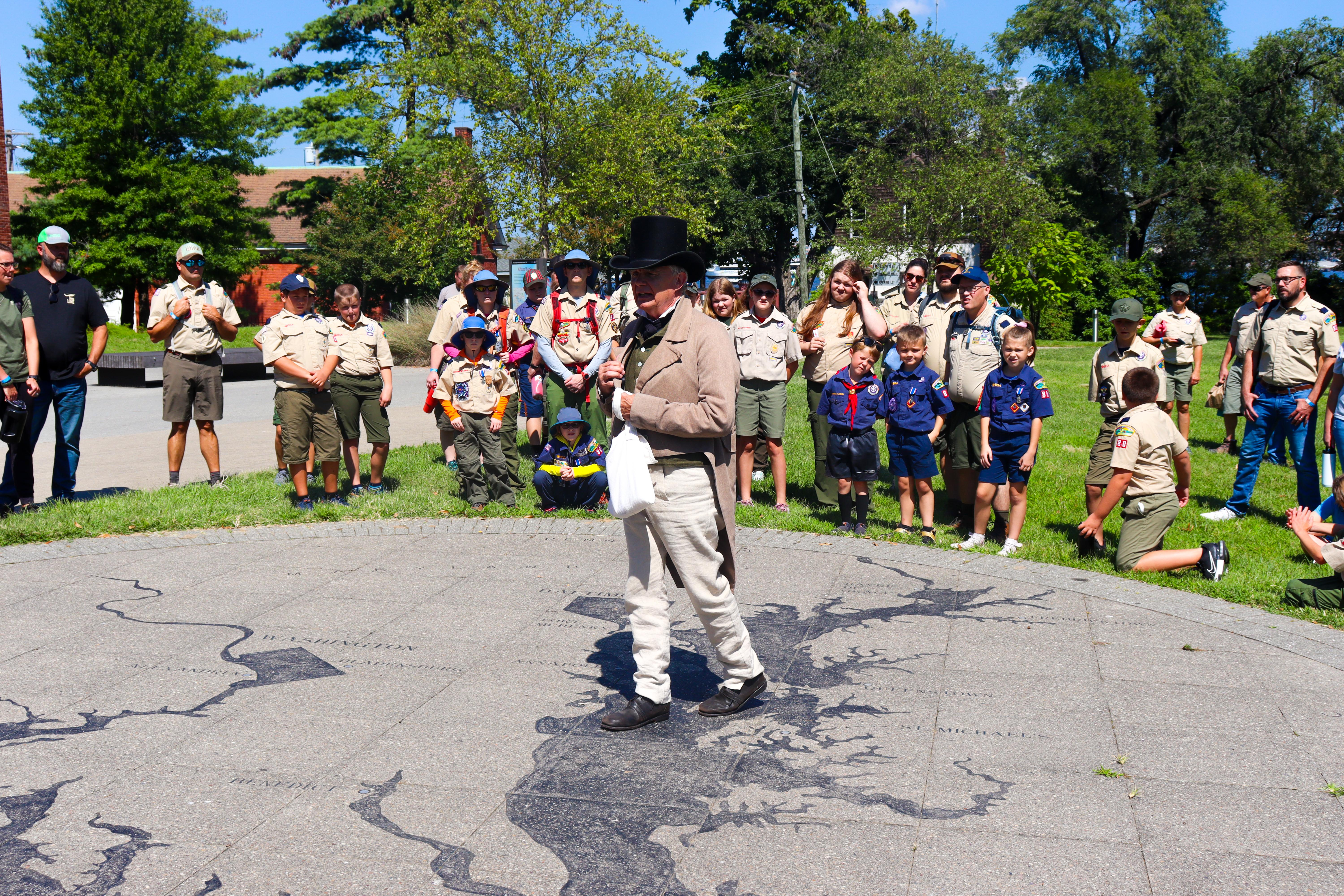 Ranger dressed in living history garb delivers a program to a group of boy scouts.