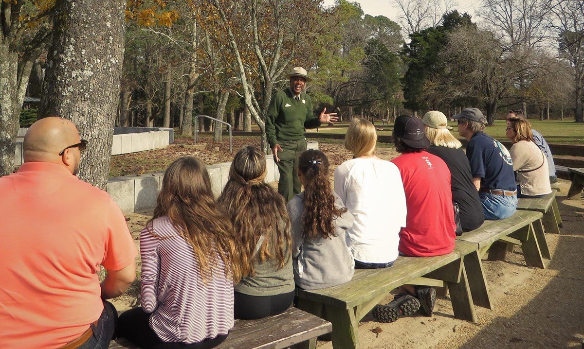 National Park Ranger stands before visitors giving a tour.
