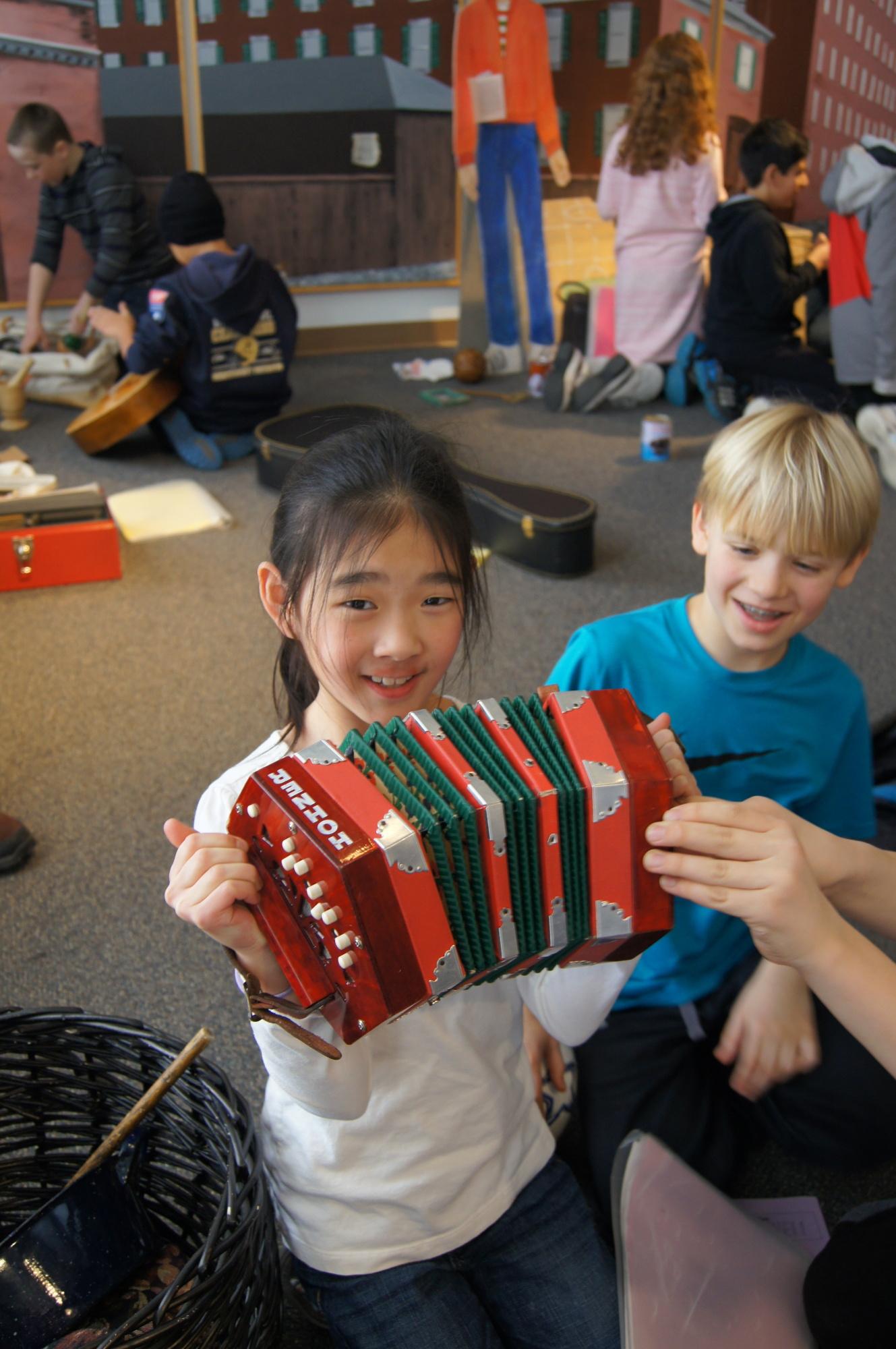 A child plays with a colorful accordion