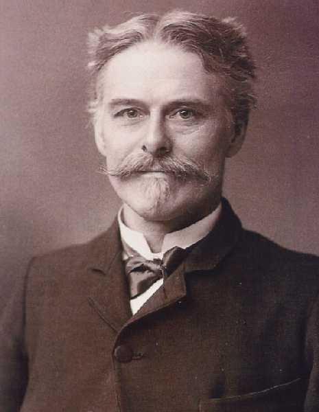 sepia toned photograph of white man with mustache wearing black jacket and bow-tie