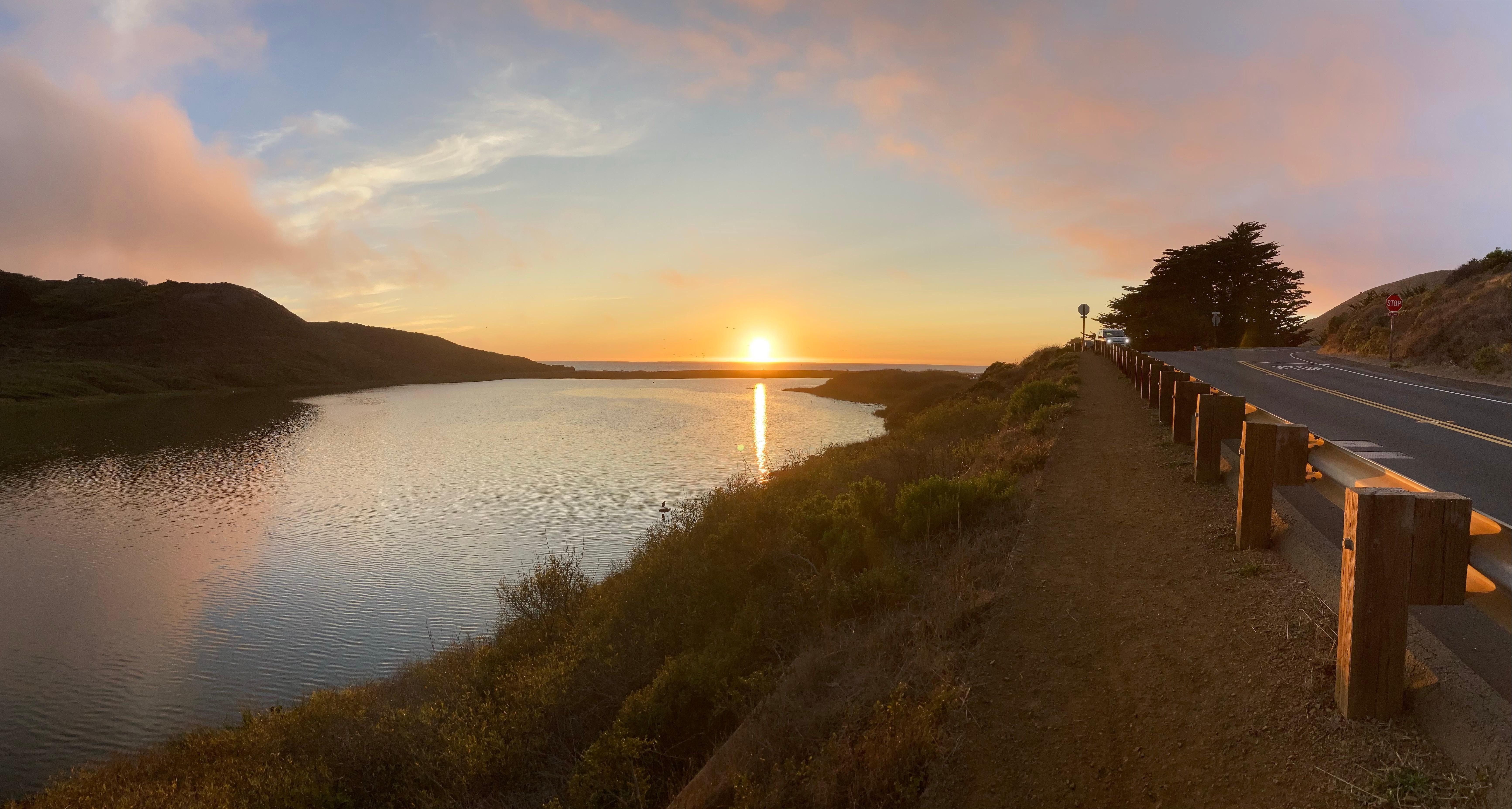 Sunset colors over Rodeo Lagoon. The water is glassy and reflects the colors.