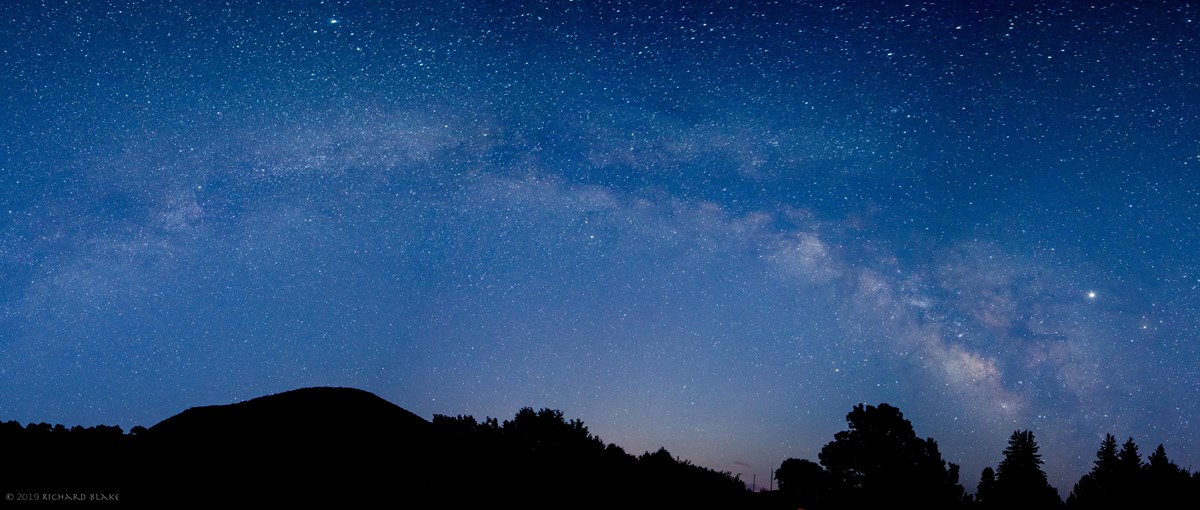 Milky Way and stars in the night sky over the silhouette of Capulin Volcano