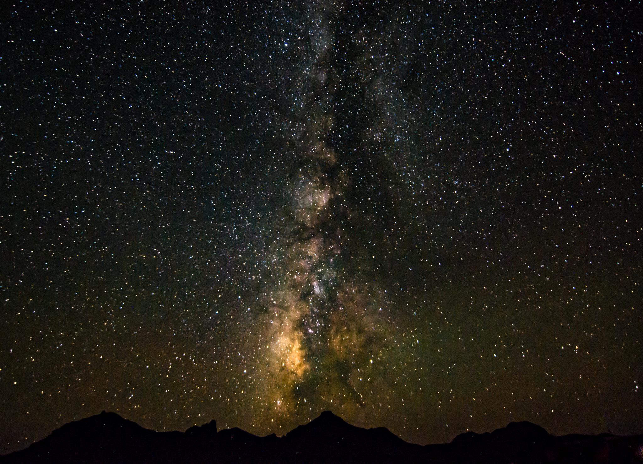 The Milky Way stretches across the night sky over the Chisos Mountains.
