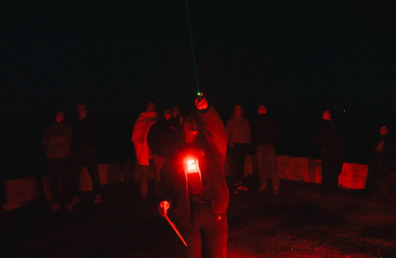 A Ranger points a green laser pointer to the night sky during a constellation tour.