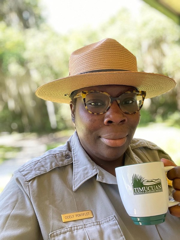 park ranger holds cup of coffee